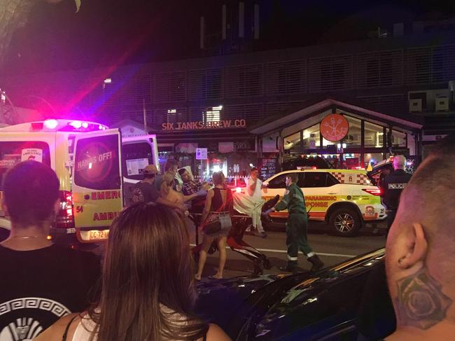 An injured man is treated by ambulance on the scene at Mitchell St in the early hours of Sunday morning. Picture: Josh Spasaro