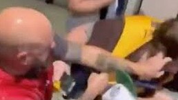 A Melbourne supporter attacking a disabled Hawthorn fan. Picture/Channel 9