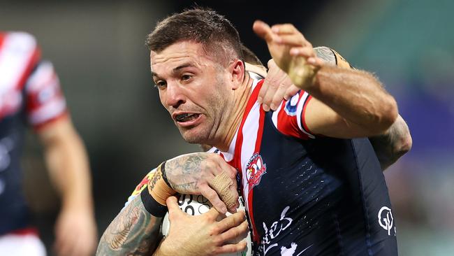 SYDNEY, AUSTRALIA - APRIL 10: James Tedesco of the Roosters is tackled during the round five NRL match between the Sydney Roosters and the Cronulla Sharks at Sydney Cricket Ground, on April 10, 2021, in Sydney, Australia. (Photo by Mark Kolbe/Getty Images)