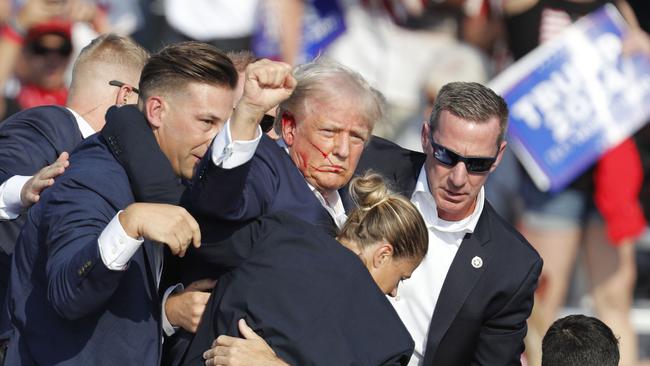 Donald Trump is rushed off stage by secret service agents after he was shot in Butler, Pennsylvania on Saturday night. Picture: EPA