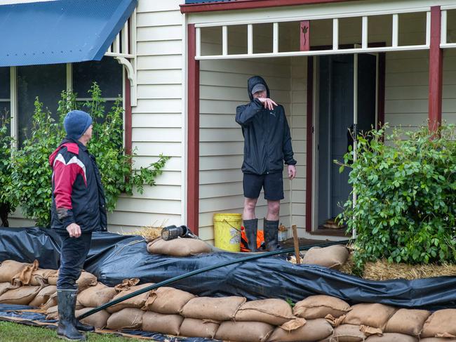 Lee and Daniel Hamilton set up a pump to drain the water from under floorboards of son and brother Adam’s Rochester House. Picture: Jason Edwards