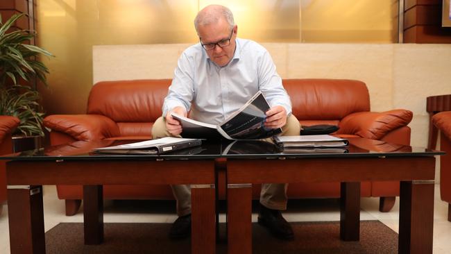 PM Scott Morrison catches up with some paperwork on a refuelling stop on the way to the G7 in France. Picture: Adam Head