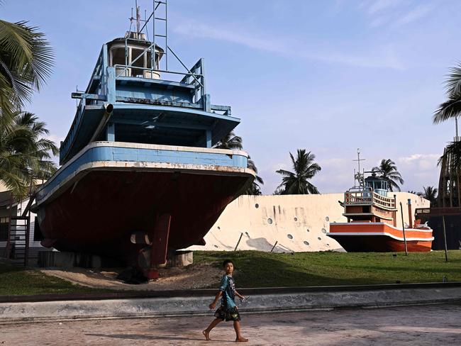 A boy walks past the Ban Nam Khem Tsunami Museum in the southern Thai province of Phang Nga. Picture: AFP