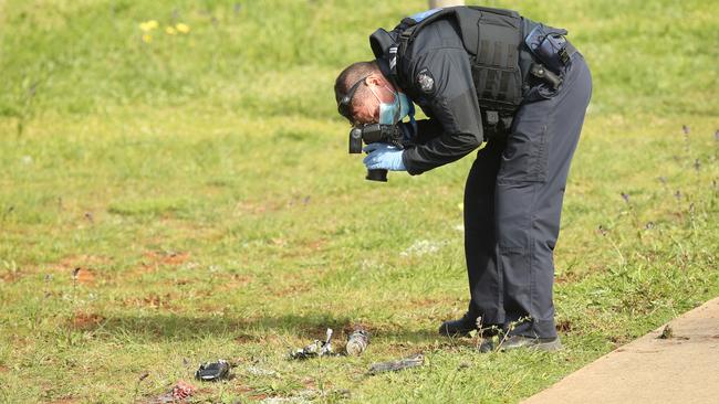 Police examine shrapnel. Picture: Alan Barber