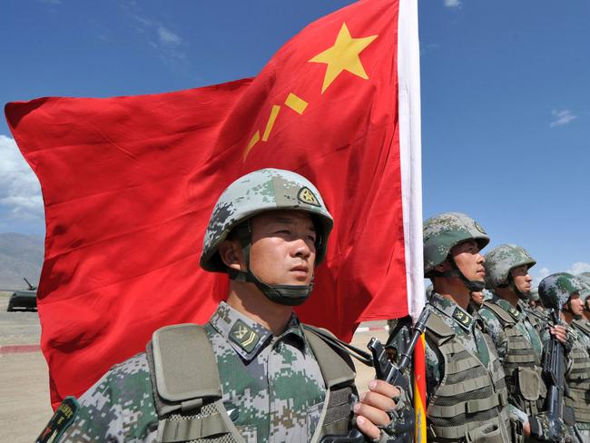 (FILES) In this file photo taken on September 19, 2016, a Chinese soldier holds a Chinese flag during Peace Mission-2016 joint military exercises of the Shanghai Cooperation Organization (SCO) in the Edelweiss training area in Balykchy, some 200 km from Bishkek. - During Xi Jinping's decade-long rule China has built the world's largest navy, revamped the world's largest standing army and amassed a nuclear and ballistic arsenal to trouble any foe. (Photo by Vyacheslav OSELEDKO / AFP)