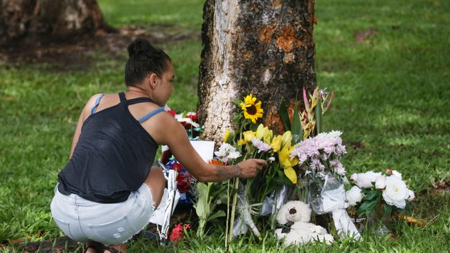 The scene of a fatal traffic crash at Manoora on February 14, 2022, where an allegedly stolen Toyota left Pease Street near the Saltwater Creek bridge and crash into a tree. A 14 year old boy was declared dead at the scene, and five other children aged 12 to 15 were taken to Cairns Hospital with injuries. Denise Weazael of Manoora lays some flowers at the scene of the crash. Picture: Brendan Radke