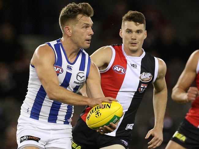 Shaun Higgins of the Kangaroos (left) runs the ball forward during the Round 23 AFL match between the St Kilda Saints and the North Melbourne Kangaroos at Etihad Stadium in Melbourne, Sunday, August 26, 2018. (AAP Image/Hamish Blair) NO ARCHIVING, EDITORIAL USE ONLY