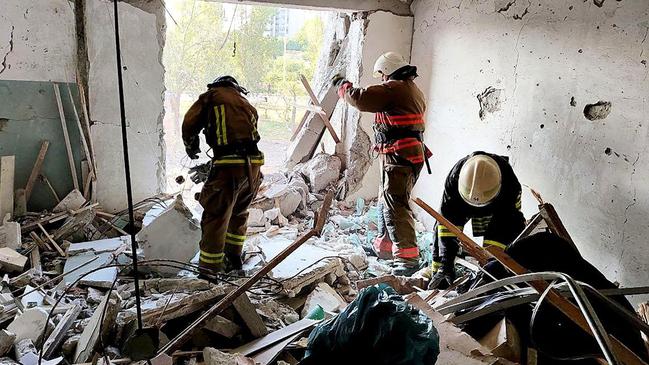 Ukraine's State Emergency Service rescuers working in the wreckage of an apartment building that destroyed after being hit by a missile strike. Picture: AFP