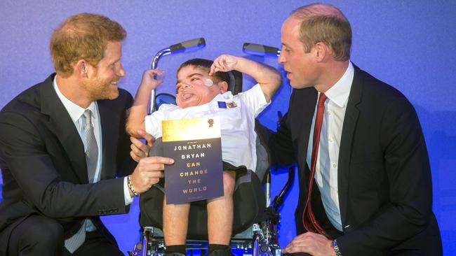Prince Harry, left and Prince William give an award to 11-yea- old Jonathan Ryan during The Diana Award 2017 ceremony. Picture: AP