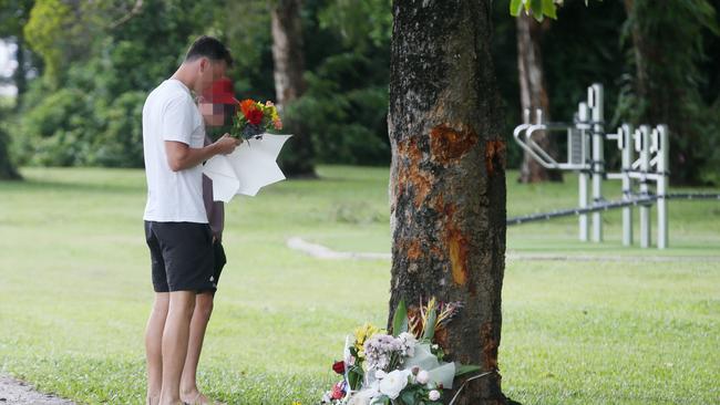 A man and a boy lay floral tributes at the scene of the crash. Picture: Brendan Radke