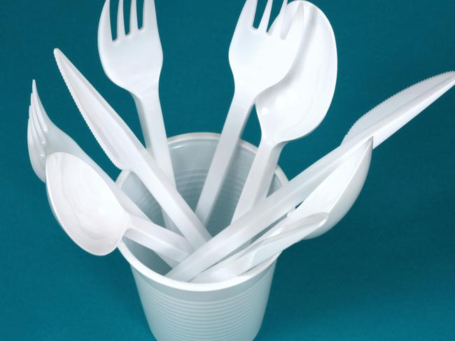 Plastic cutlery in a paper glass