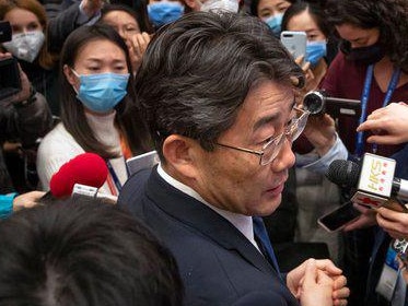 Dr George Gao surrounded by press pack. Picture: AP