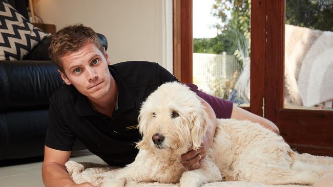 Aaron O'Toole with his parent's dog Stan, 9 who has megaesophagus. Picture: Matt Loxton/AAP