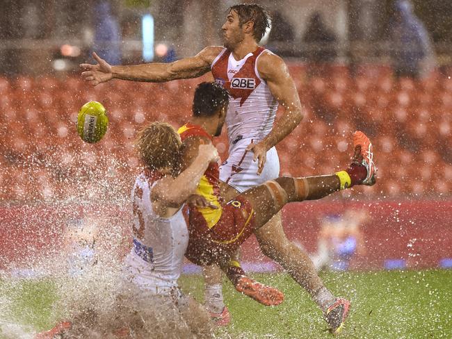 Isaac Heeney tackles Aaron Hall in the sloppy conditions. Picture: AAP