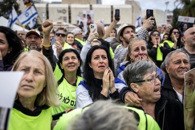 Relatives and friends of Israeli hostages watch the release of four women soldiers from captivity in Gaza, on a screen at 'Hostage Square' in Tel Aviv