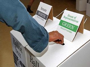 Man voting in election - ballot box signs "Senate White Ballot papers' and "House of Representatives Green Ballo...