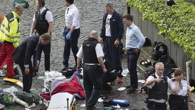 Upset colleagues, emergency personnel and MP Tobias Ellwood at the scene of the officer’s stabbing. Picture: Stefan Rousseau/PA via AP.