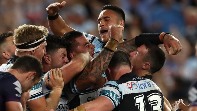 Andrew Fifita is mobbed by Sharks teammates after scoring the go-ahead try.