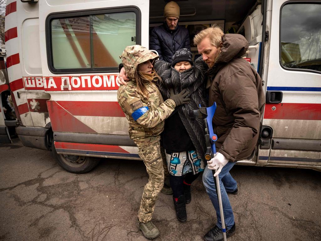 A woman is helped out of an ambulance after fleeing her home in the Kyiv suburb of Stoyanka. Picture: AFP