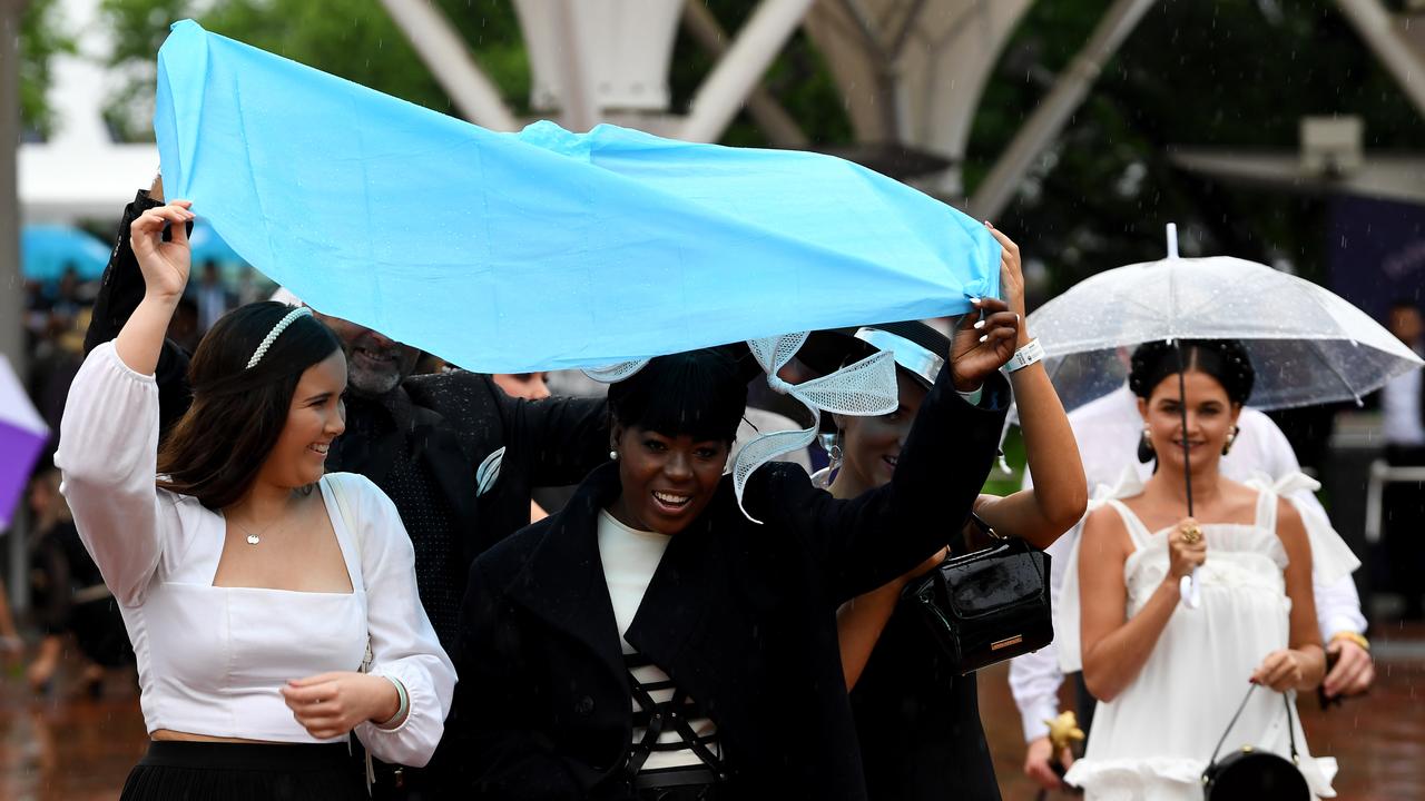 Staying dry at Flemington is a group effort. Picture: AAP