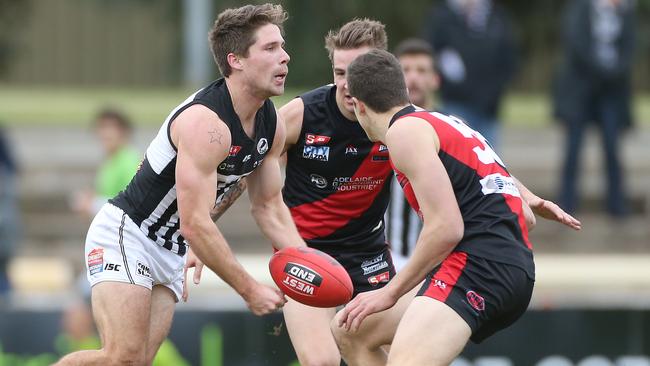 Steven Summerton dishes off the ball before getting sandwiched at Richmond Oval. Picture: Stephen Laffer.