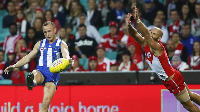 Billy Hartung kicks a goal past an outstretched Jarrad McVeigh. Picture: AAP