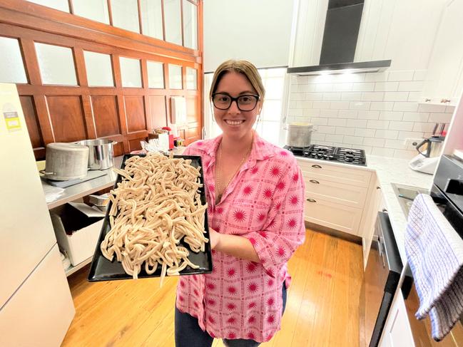 Giovanna Castorina, the owner of Giovanna's Cucina in Home Hill, inside the brand-new kitchen she installed in the old bank building. She holds a tray of fresh pasta.