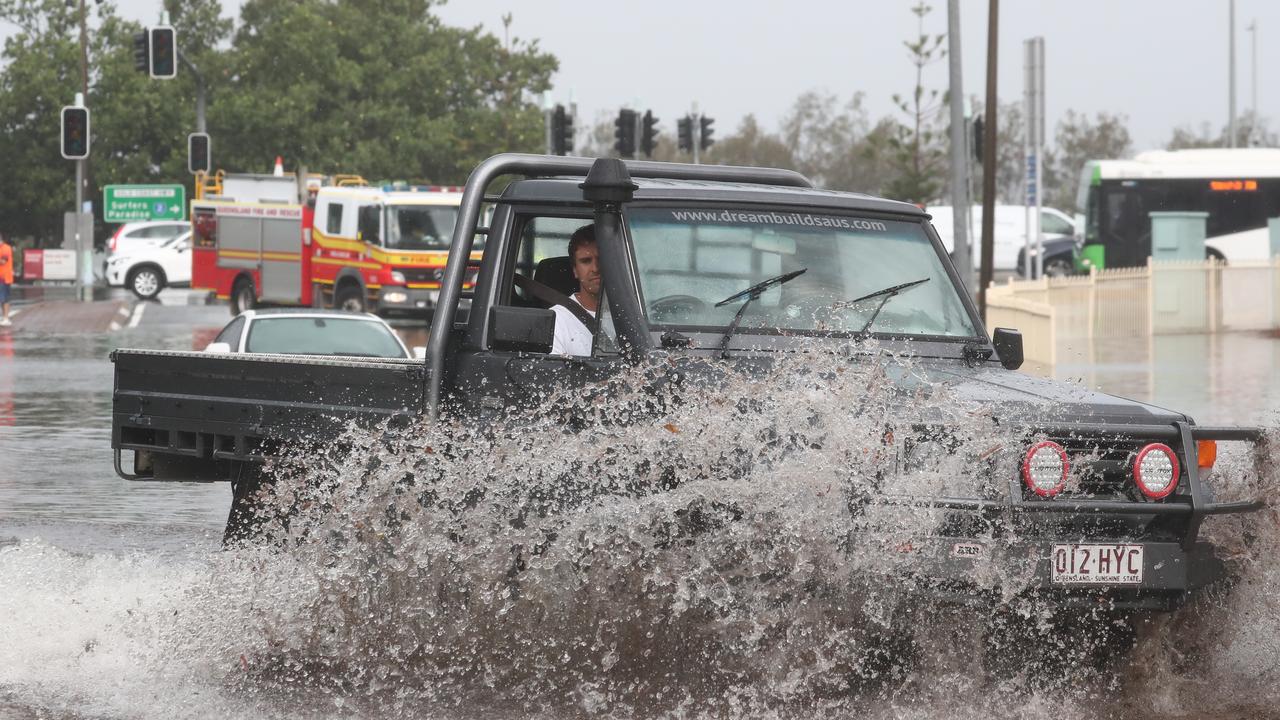 A car drives through water on Queen St in Southport after a storm lashes the Gold Coast. Photograph : Jason O’Brien