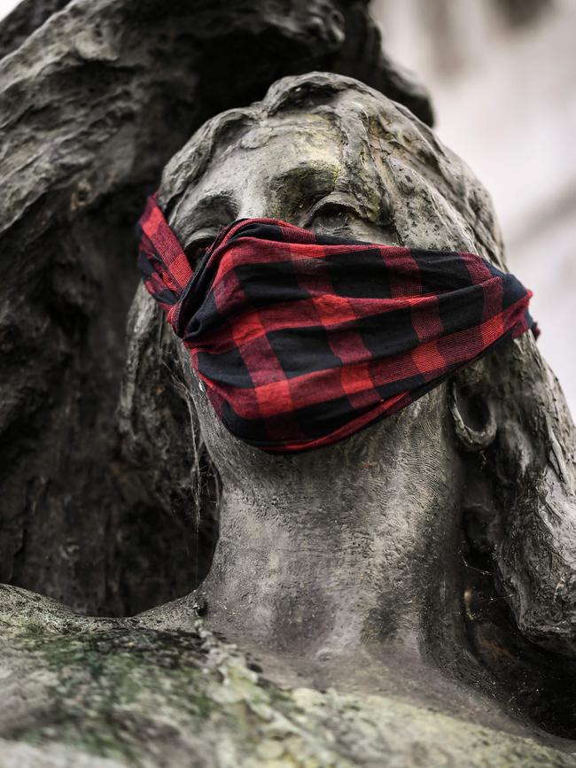 A sculpture, part of the Monumento de los Espanoles (Monument of the Spanish) in Buenos Aires, with a scarf as a face mask.