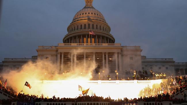 An explosion caused by a police munition is seen while supporters of US President Donald Trump gather in front of the US Capitol Building in Washington.