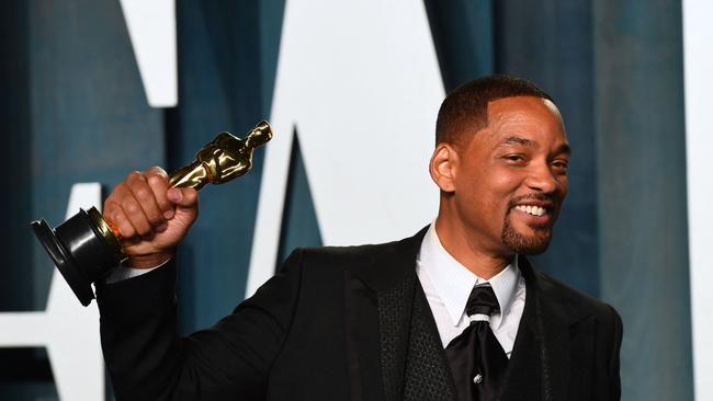 Smith holds his award for Best Actor in a Leading Role for "King Richard", received just minutes after hitting Rock.