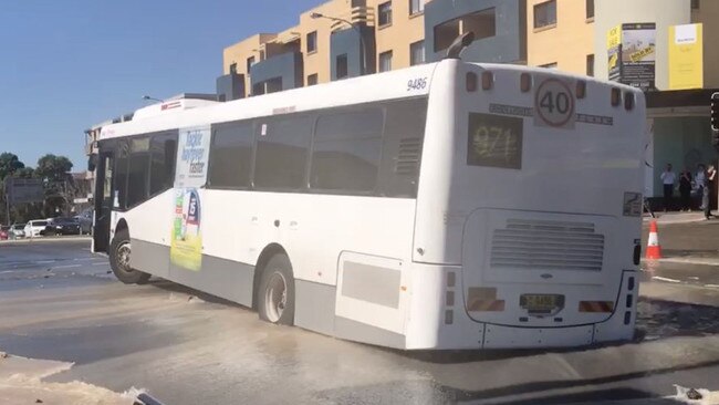 A bus has fallen into a sinkhole on the Kingsway in Caringbah after a burst water main damaged the road. Picture: Supplied