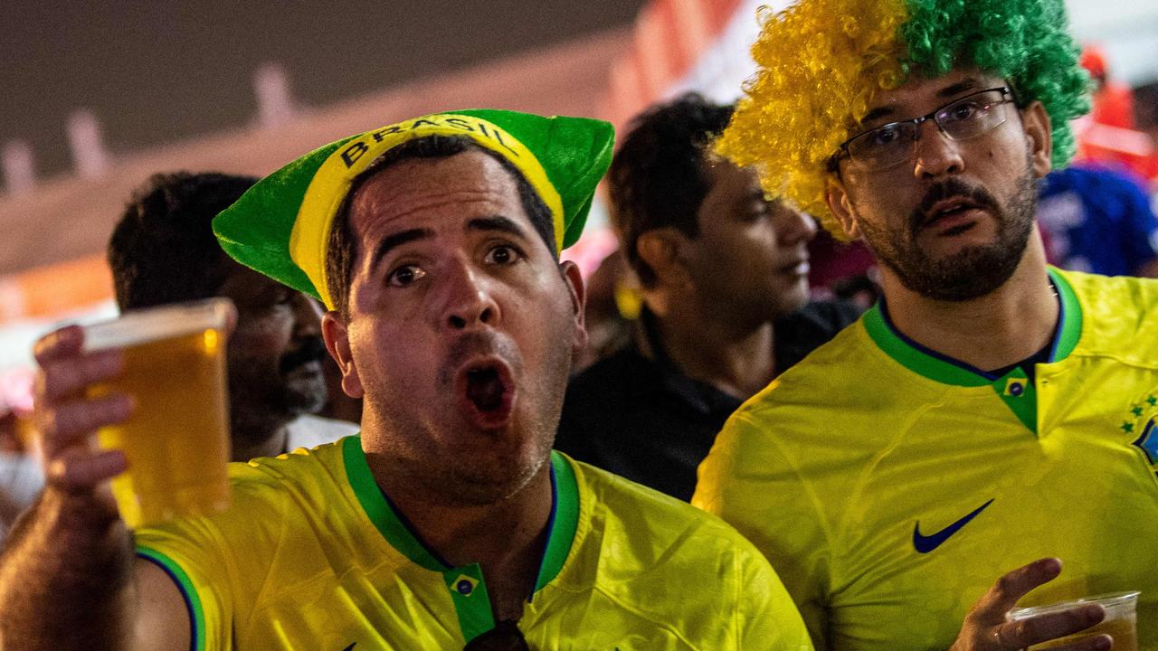 Brazil supporters drink beer as they attend the FIFA Fan Festival at Al Bidda park in Doha on November 20, 2022, on the opening of the Qatar 2022 World Cup football tournament. (Photo by Philip FONG / AFP)