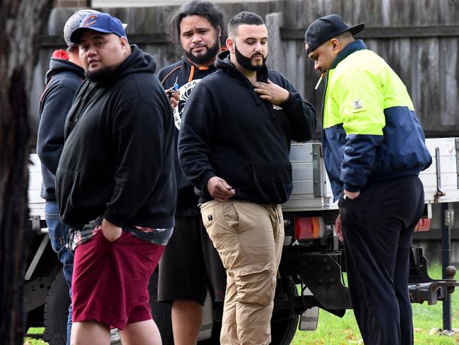People watch on as AFP officers search and collect evidence from a house in Gladstone Park. Picture: Nicole Garmston