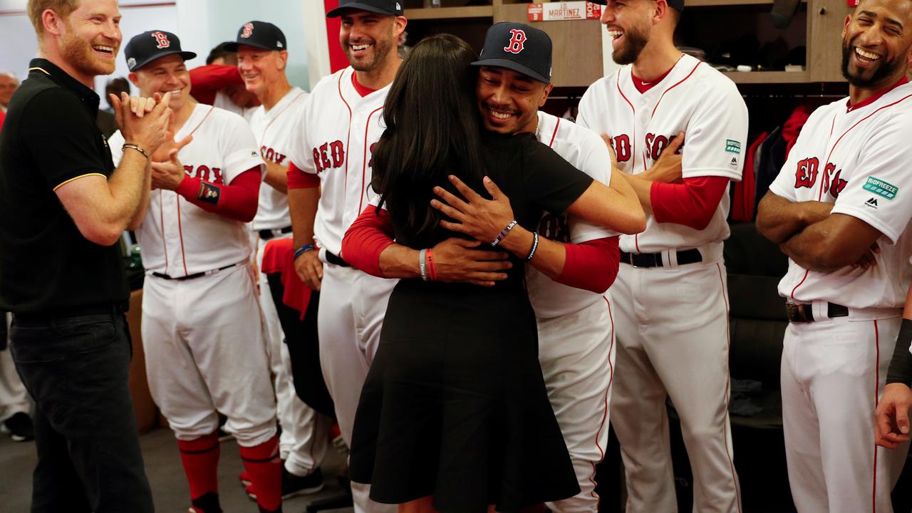 Prince Harry laughs as Meghan, Duchess of Sussex gives a special hug to one Red Sox player. Now we know why. Picture: Peter Nicholls/Pool