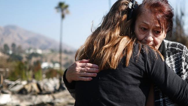 Araxy Manookian receives a hug in front of her Pasadena home that was destroyed in the Eaton Fire. Picture: Getty Images via AFP