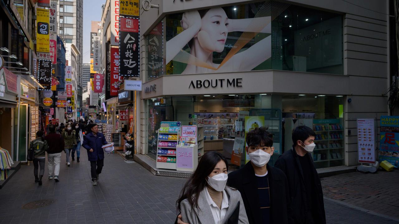 Pedestrians wearing face masks, amid concerns about the spread of the COVID-19 novel coronavirus, walk through the Myeongdong shopping district of Seoul on March 6, 2020. Picture: Ed Jones/AFP