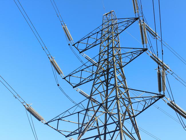 Photo showing a tall high-voltage transmission tower, which is known in the UK and much of Europe as an electricity pylon.  The photo shows a section of the tower, with wires, conductors and insulator strings.  This top part of the structure is named the 'peak', while the section beneath is the 'cage'.