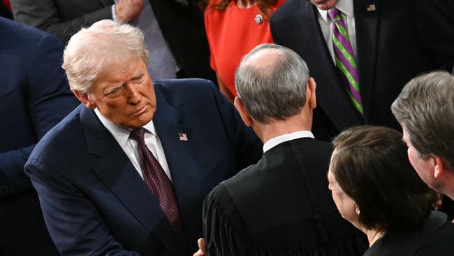 US President Donald Trump greets US Supreme Court Chief Justice John Roberts.