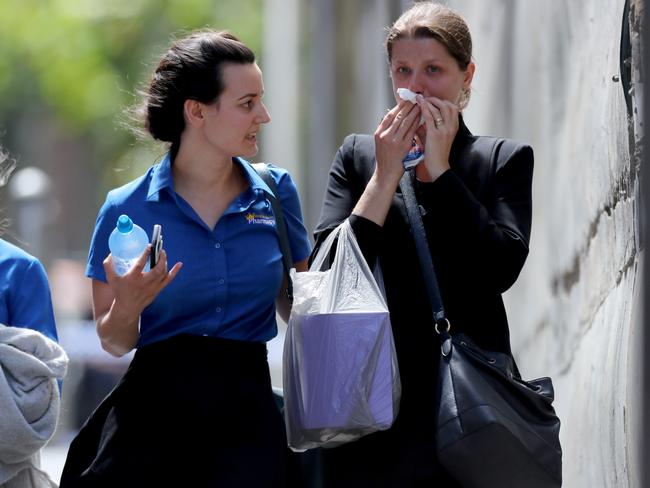 A distressed woman is comforted leaving the scene at Bourke St. Picture: David Geraghty