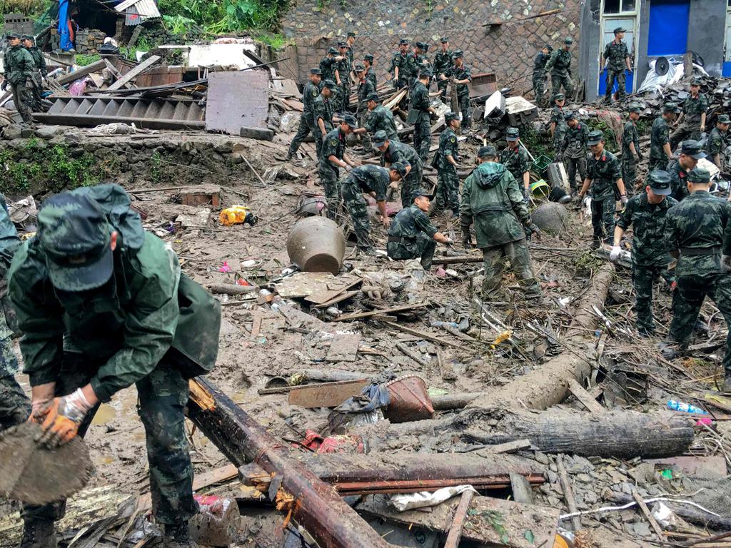 Rescuers in China look for survivors in the rubble of damaged buildings after a landslide caused by torrential rain from Typhoon Lekima. Picture: AFP