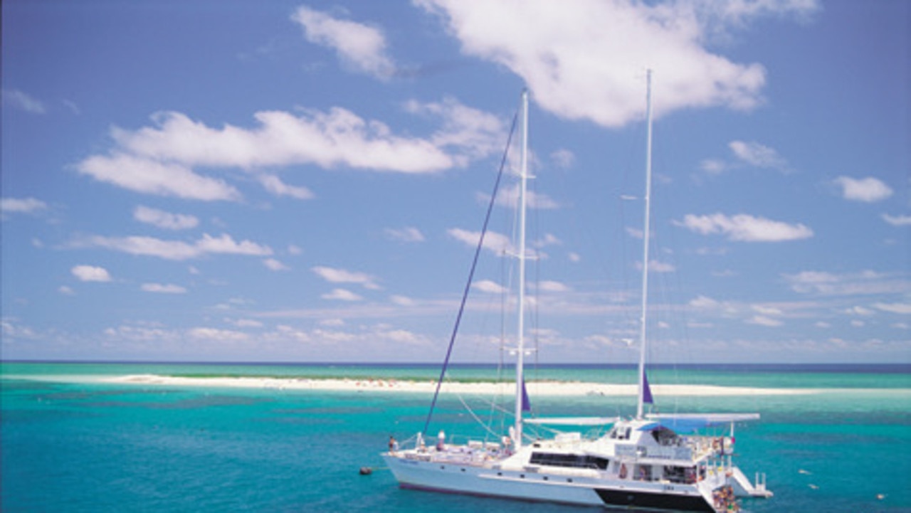 Quicksilver's catamaran takes tourists to the sand cay at Michaelmas Reef for snorkelling and swimming.