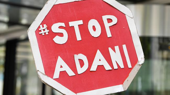 A stop Adani placard is held by a protester during a demonstration outside of Siemens Mobility. Picture: AAP