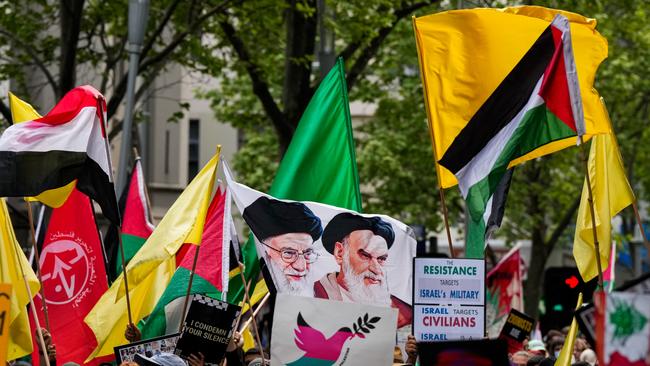 A flag bearing the face of Iran's Supreme Leader, Ayatollah Ali Khamenei is waved on in Melbourne on Sunday. Picture: Getty Images