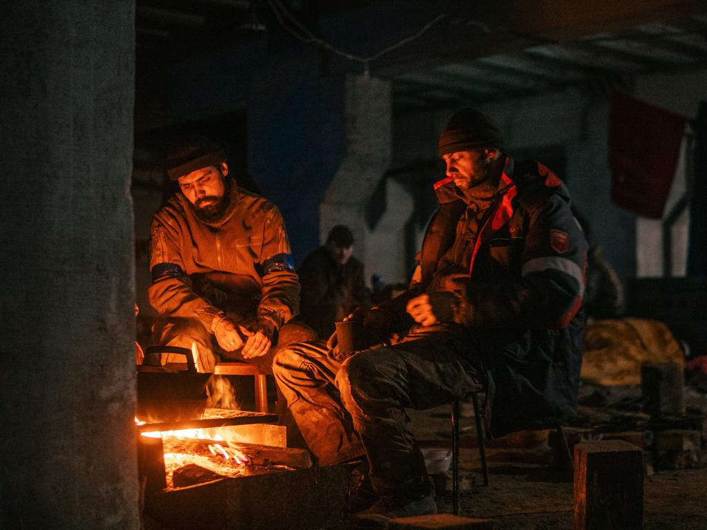 Two men stay warm by a fire inside the plant, and used areas underneath the mill to take shelter. Picture: Dmytro Kozatsky