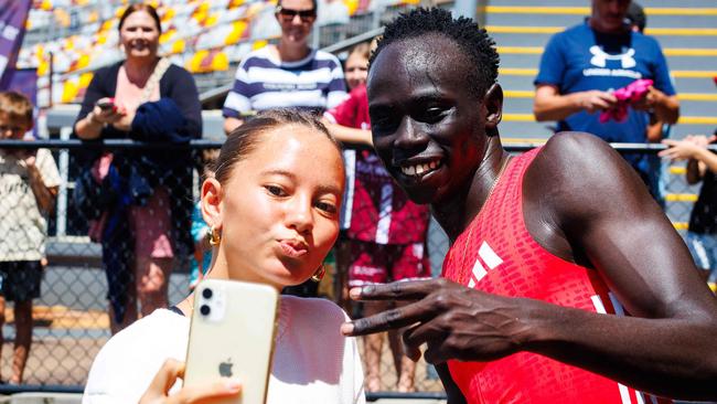 Australian sprinter Gout Gout poses for a selfie with a fan.