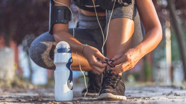 Sporty woman tying shoes to run