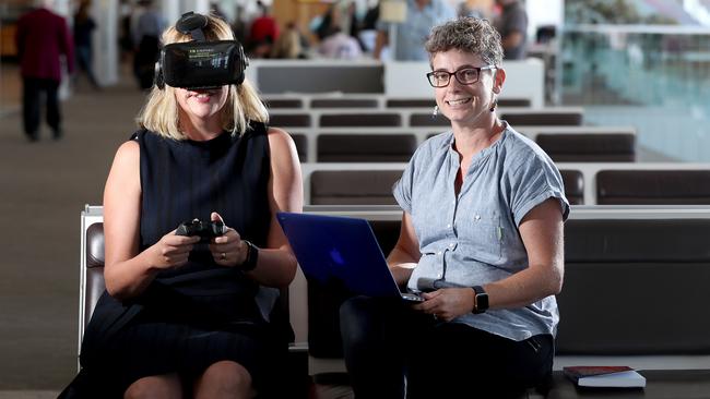 Angelique Foran and Dr Emma Johnston test out VR goggles to combat fear of flying at Adelaide Airport. Picture: Calum Robertson