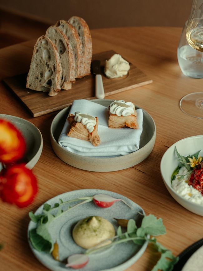 Green almond danish (centre) and a plate of crudite with leek top sabayon in the foreground. Picture: Arianna Harry