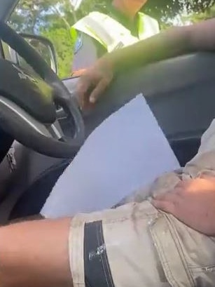 The officer finally drops the documents through the car window. Picture: Twitter/@CookerWatch